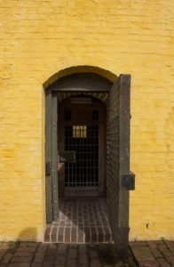 a door interrupts the yellow brick of fort moultrie on sullivan's island, south carolina, photographed by jamie bannon photography.