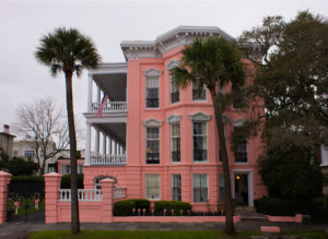 a large pink building known as the palmer home in charleston, south carolina, photographed by jamie bannon photography.