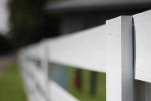 a white fence on a farm in bluegrass country, kentucky, photographed by jamie bannon photography.