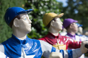 a row of lawn jockeys at keeneland race track in lexington, kentucky, photographed by jamie bannon photography.