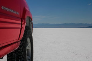 red jeep grand cherokee parked on the bonneville salt flats in utah, photographed by jamie bannon photography.