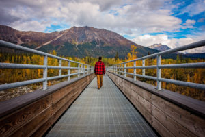 a visitor walks the footbridge into mccarthy, alaska, photographed by jamie bannon photography.