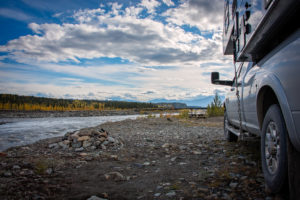 a truck camper parked for the night by the river just outside mccarthy, alaska, photographed by jamie bannon photography.