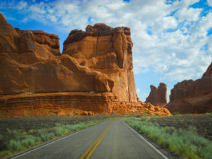 road through the giant red rocks of moab, utah, photographed by jamie bannon photography.