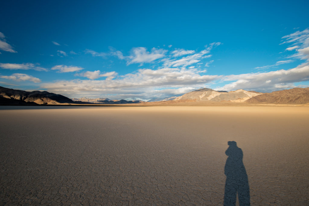 shadow of the photographer during sunset over the racetrack playa in death valley, california, photographed by jamie bannon photography.