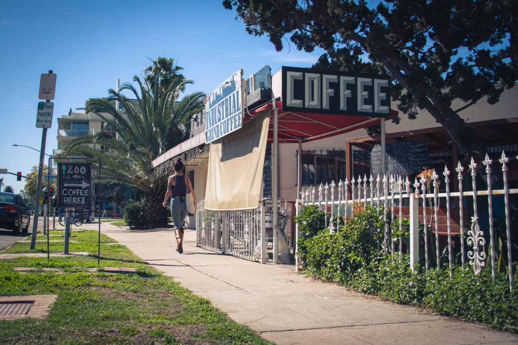 a woman walks past industrial grind coffee in san diego, california, photographed by jamie bannon photography.