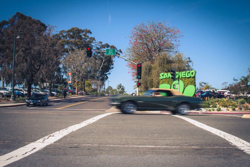 a convertible speeds through an intersection by the san diego zoo, photographed by jamie bannon photography.