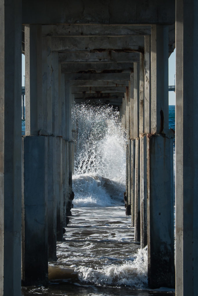 waves crash under the boardwalk at ocean beach in san diego, california, photographed by jamie bannon photography.