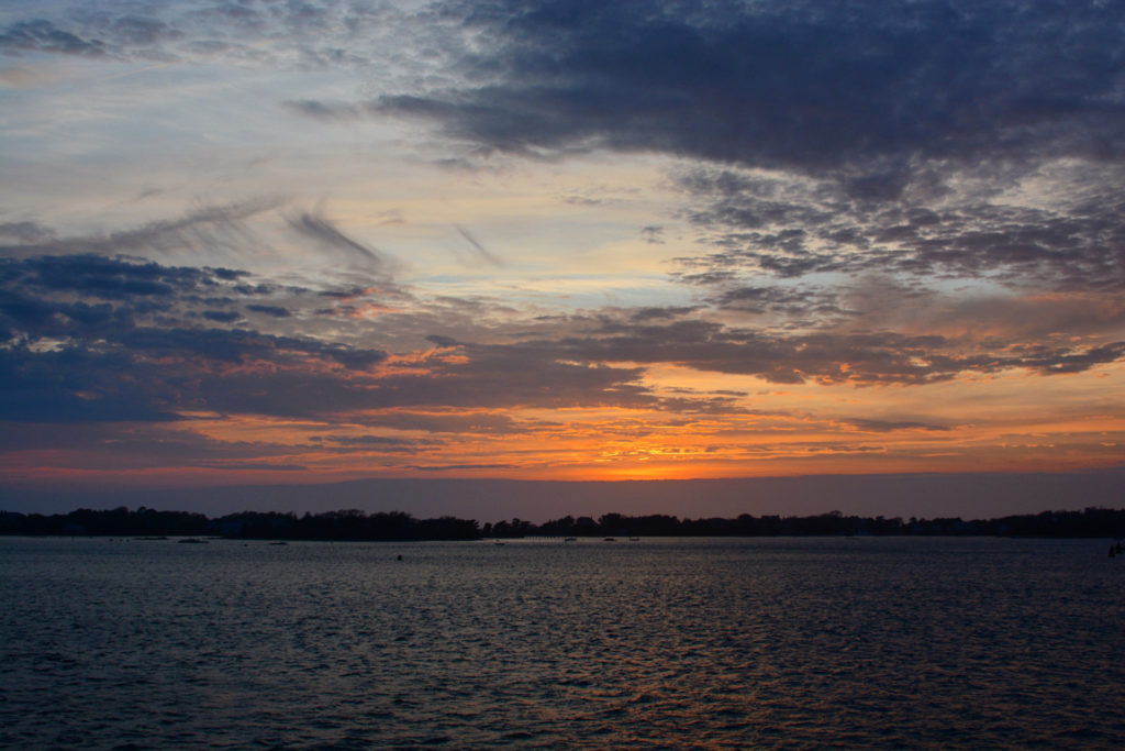sunset over the water on the ferry to martha's vineyard, photographed by jamie bannon photography.