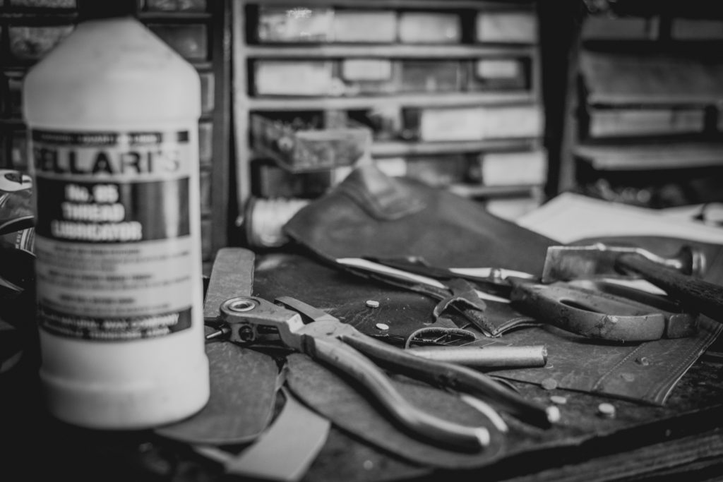 old fashioned shoe repair equipment in a cobbler shop in unionville, connecticut, photographed by jamie bannon photography.