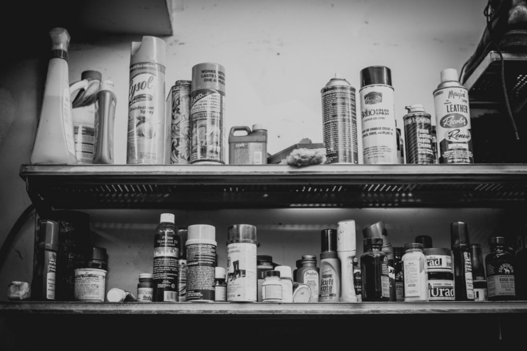 shelves lined with aerosols and sprays in a cobbler shop in unionville, connecticut, photographed by jamie bannon photography.