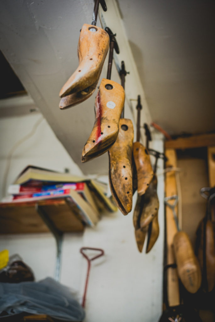 detail of shoe horns hanging from the ceiling of a cobbler shop in unionville, connecticut, photographed by jamie bannon photography.