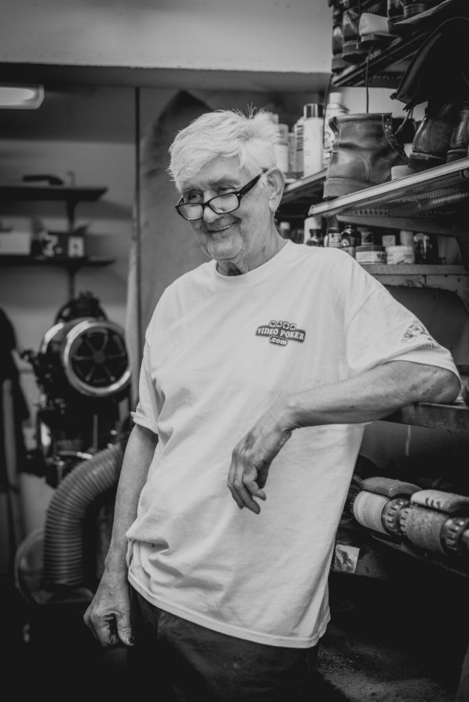 black and white portrait of a cobbler in his shoe repair shop in unionville, connecticut, photographed by jamie bannon photography.