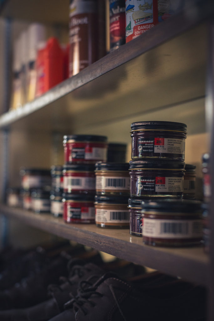jars of shoe polish on the shelf at a cobbler shop in unionville, connecticut, photographed by jamie bannon photography.