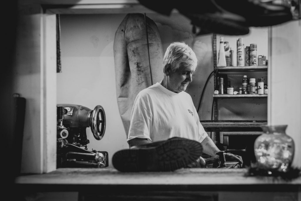 black and white portrait of a cobbler working in his shoe repair shop in unionville, connecticut, photographed by jamie bannon photography.