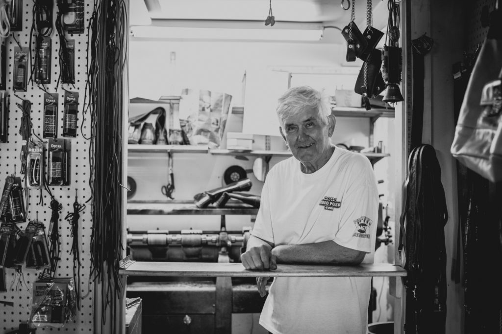black and white portrait of a cobbler in his shoe repair shop in unionville, connecticut, photographed by jamie bannon photography.