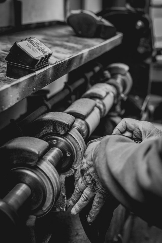 black and white close-up of a cobbler's hands working in his shoe repair shop in unionville, connecticut, photographed by jamie bannon photography.