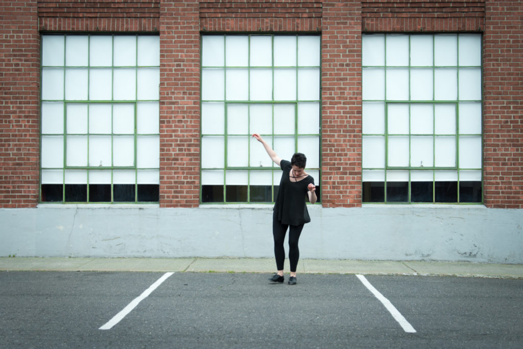 a woman tap dances outside in front of a row of windows in west hartford, connecticut, photographed by jamie bannon photography.