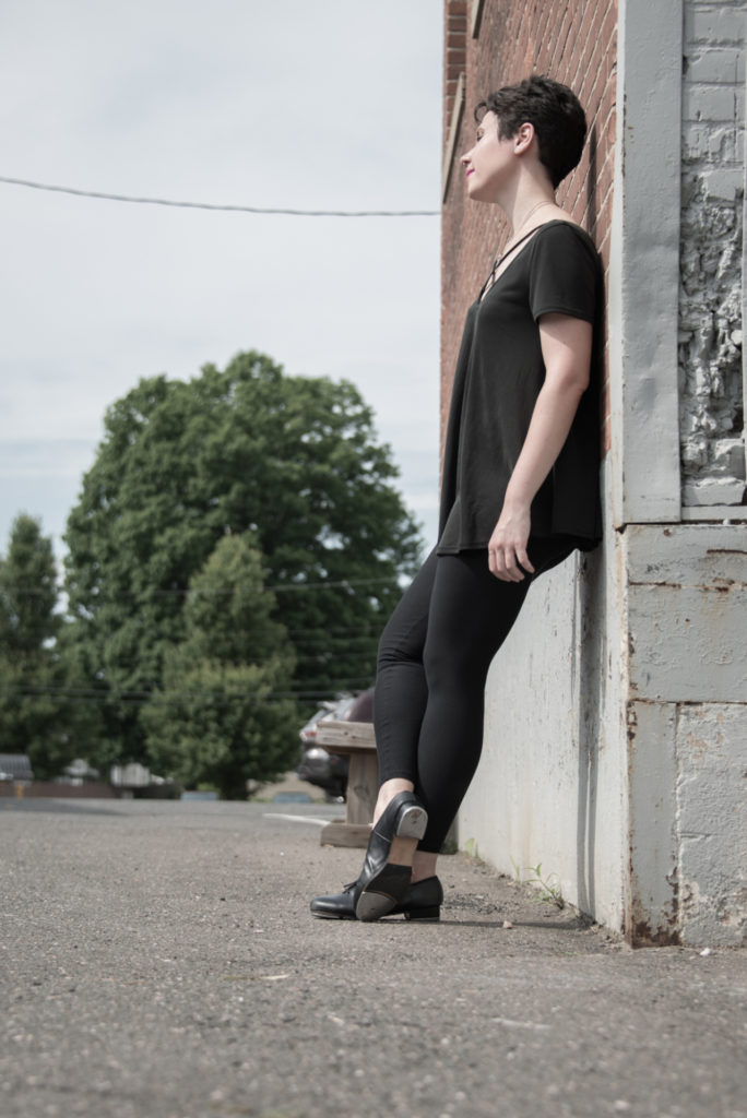 a tap dancer leans against a building in west hartford, connecticut, photographed by jamie bannon photography.