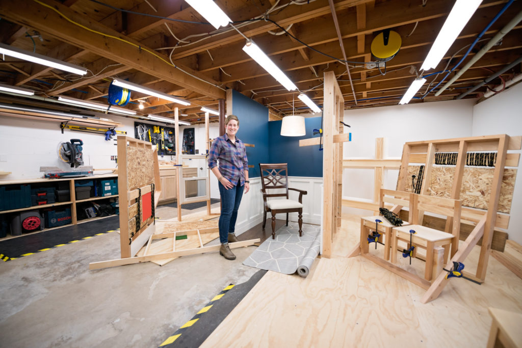 artist amy archambault standing in her studio with an installation sculpture piece in progress, photographed by jamie bannon photography.