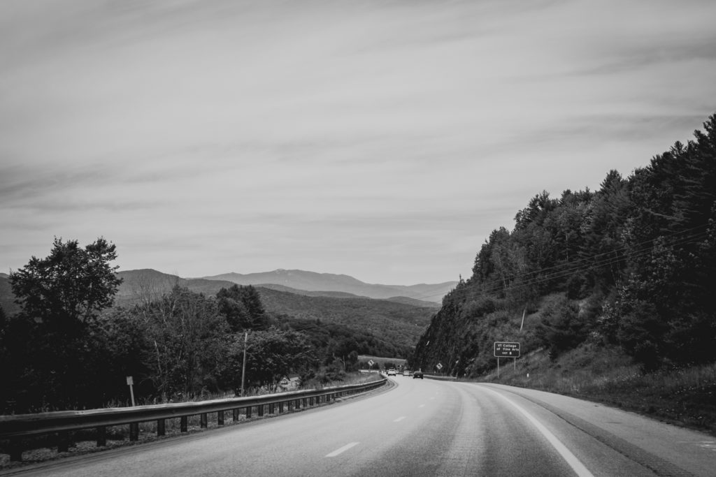 black and white image of a road winding through the mountains in vermont, photographed by jamie bannon photography.