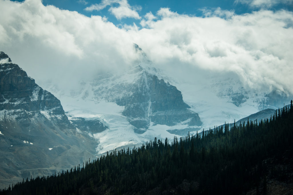 glacier with clouds over mountains on the icefields parkway through banff and jasper national parks in alberta, canada, photographed by jamie bannon photography.