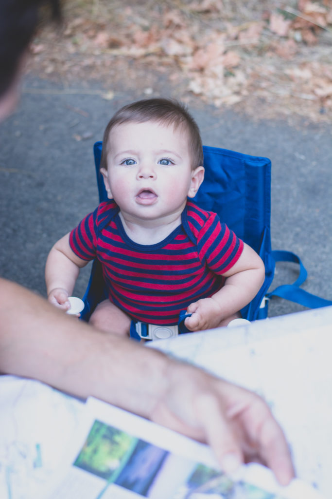 a baby watches while his dad consults a map by the roadside, photographed by jamie bannon photography.