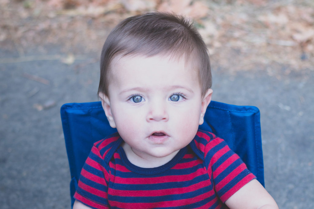 portrait of a baby sitting in his camper chair on the side of the road in washington, photographed by jamie bannon photography.