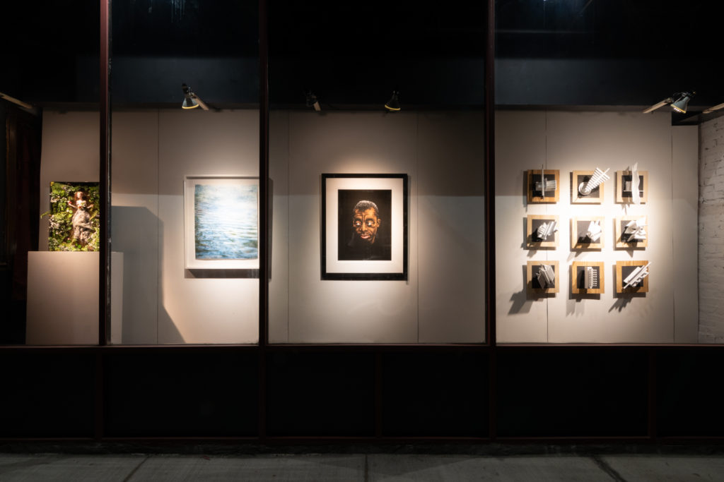 an art exhibit lit up at night, occupying the previously empty storefront windows of downtown hartford, connecticut, photographed by jamie bannon photography.