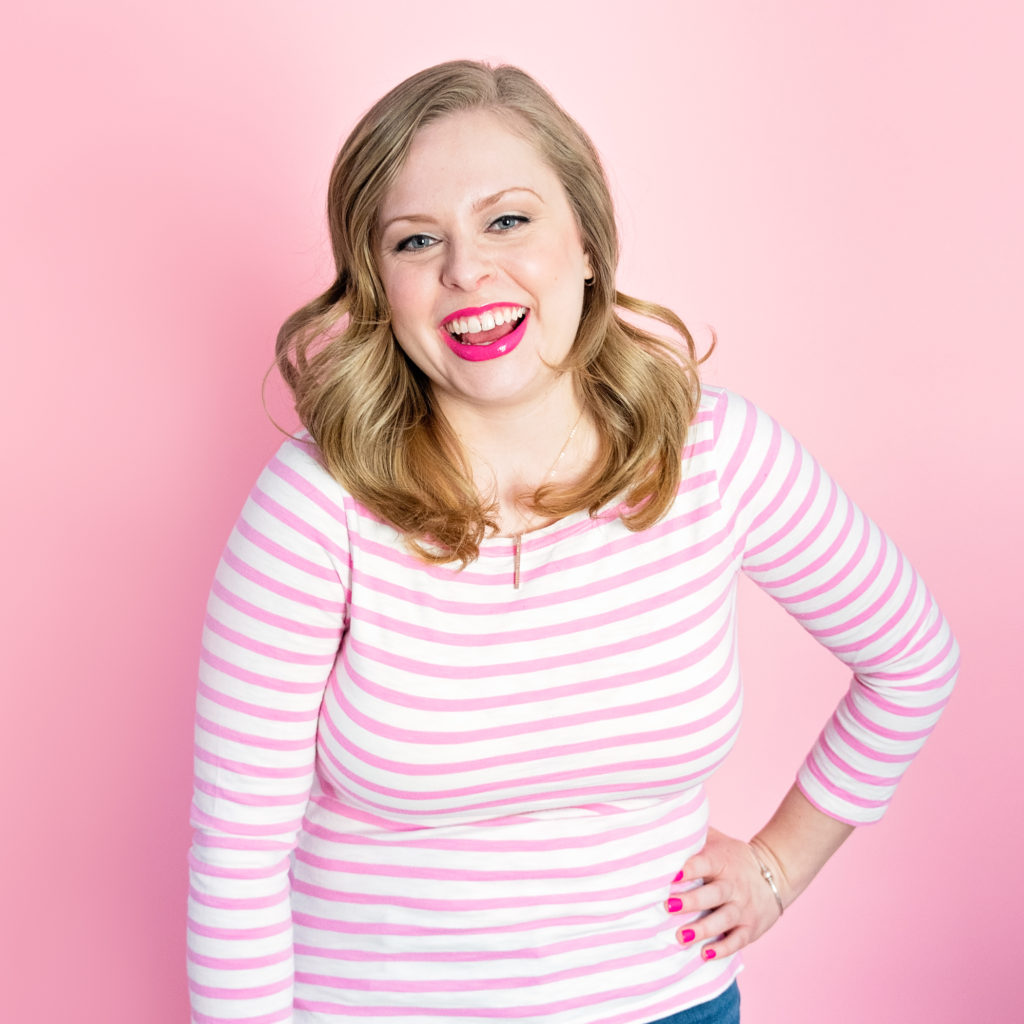 fun, contemporary headshot of a female entrepreneur in front of a pink backdrop, photographed as part of a personal branding shoot by jamie bannon photography.